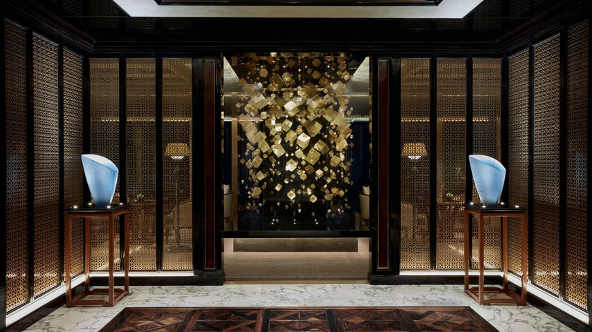 Club lounge entrance with modern gold cube installation. 