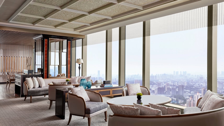 Club lounge sitting area with upholstered chairs and view of the city skyline. 