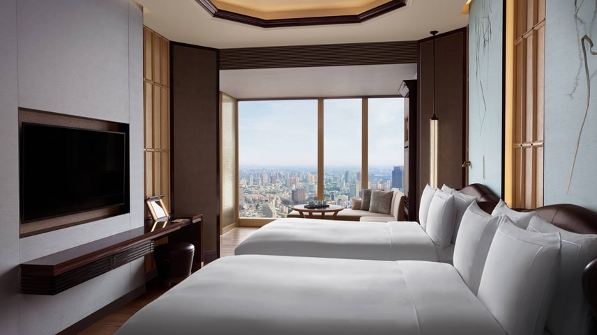 Club room with two double beds and view of the city scape beyond. 