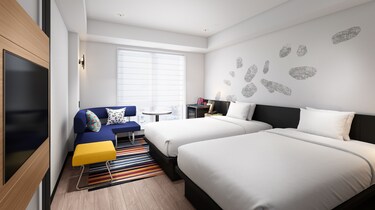 Modern twin room with two beds and colorful sofa