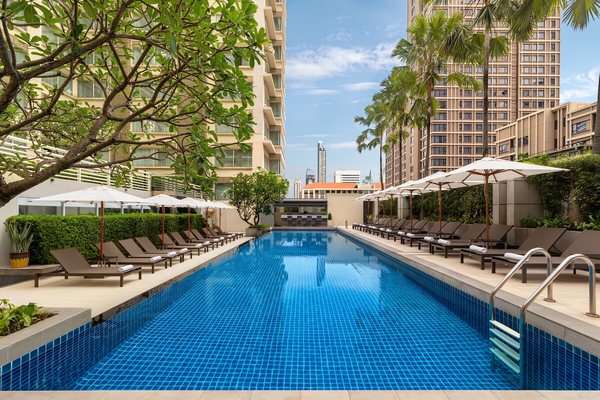 outdoor pool with sunbeds and umbrellas
