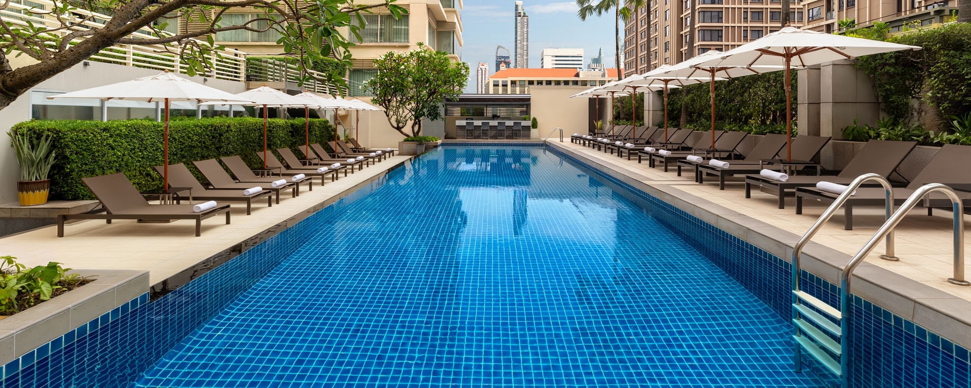 outdoor pool with sunbeds and umbrellas