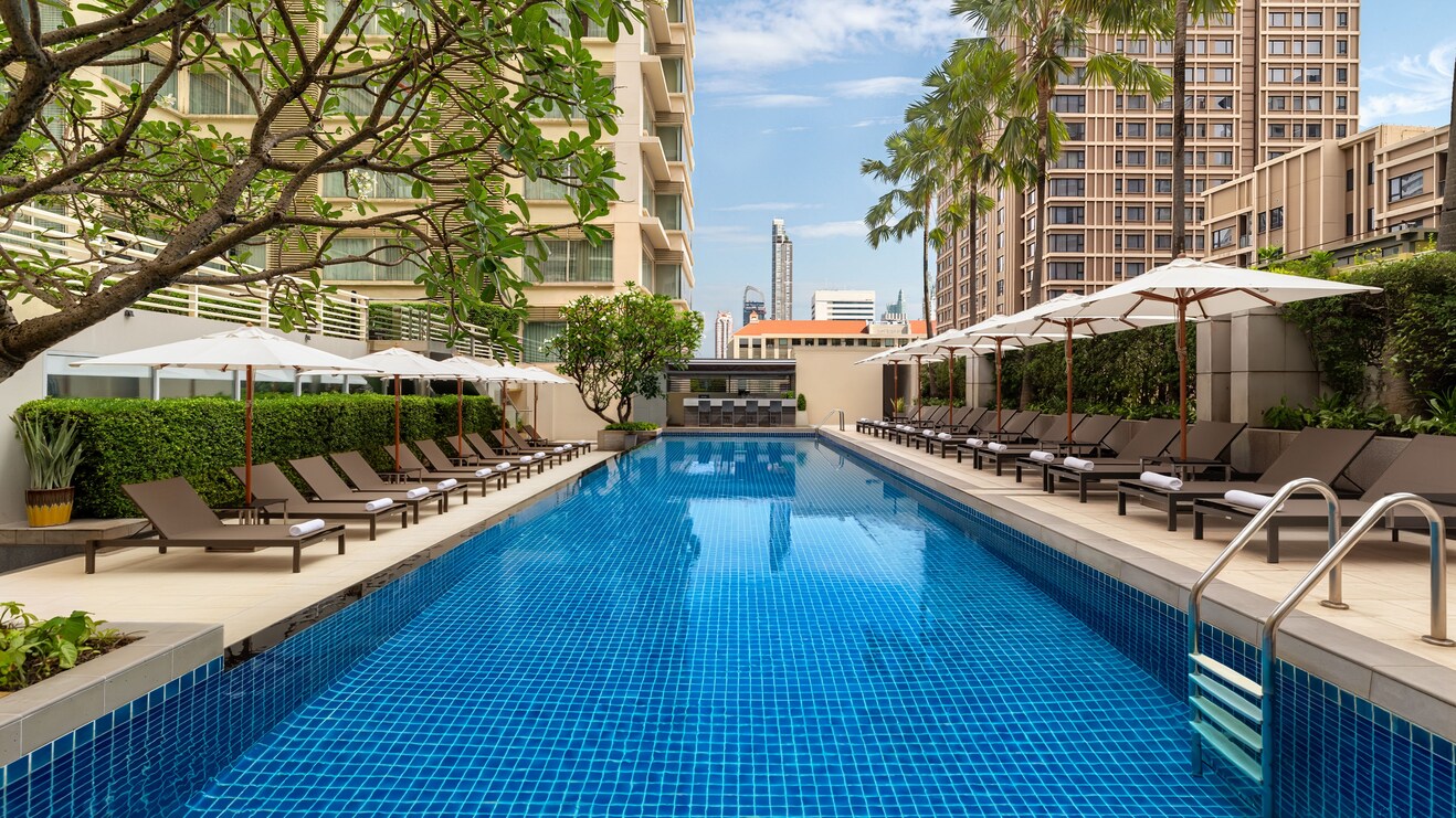 outdoor pool with sunbeds and umbrellas