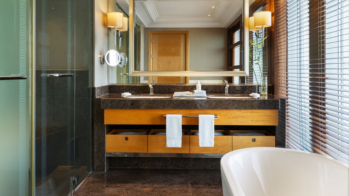 Double sink vanity, large mirror, and white tub