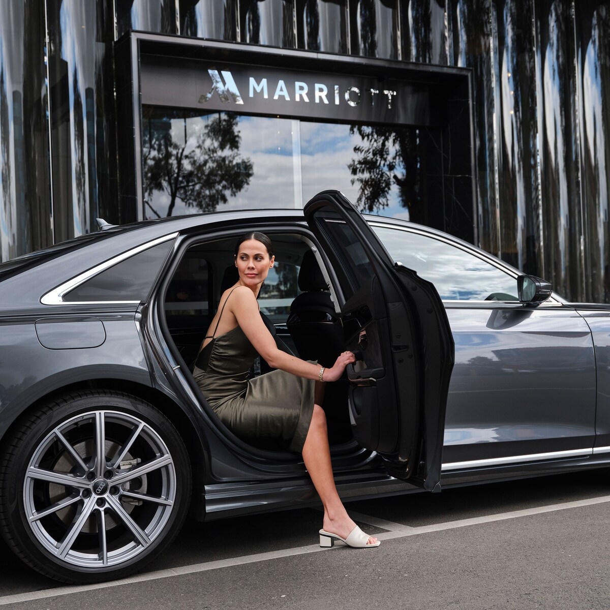 Woman stepping out of black audi car outside