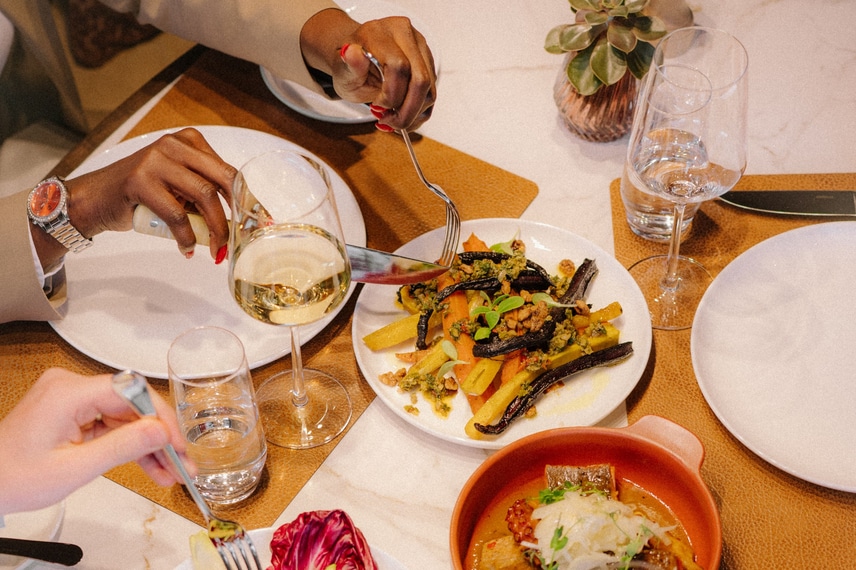 four dishes on a table with red wine