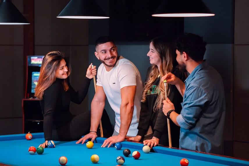 Group of friends playing pool at a sports bar