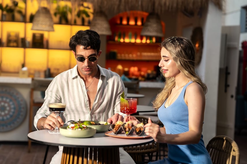 Man and woman sharing appetizers at bar counter