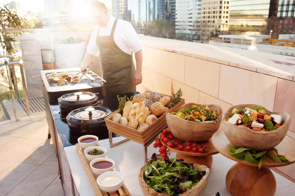 Outdoor BBQ buffet set up with chef cooking