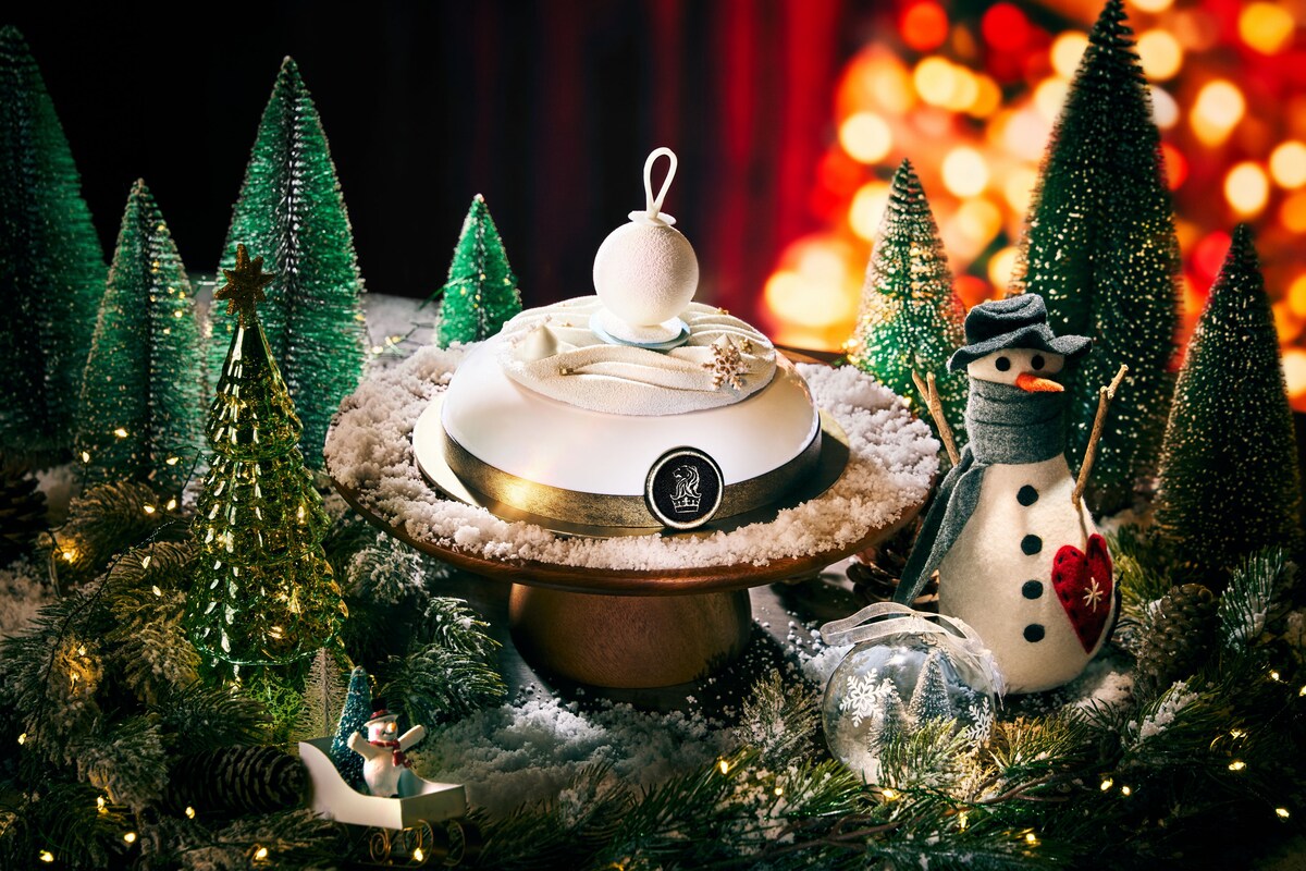 A white christmas cake topped with a white bauble