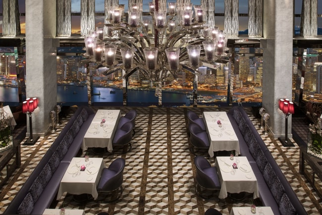 A large chandelier hangs over a dining room