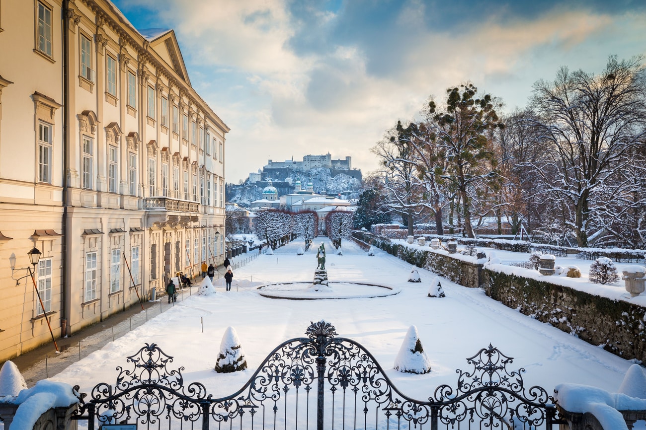 Mirabell Gardens with snowy fortress view.