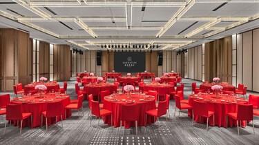 设有红色餐桌与灯光效果的宴会厅