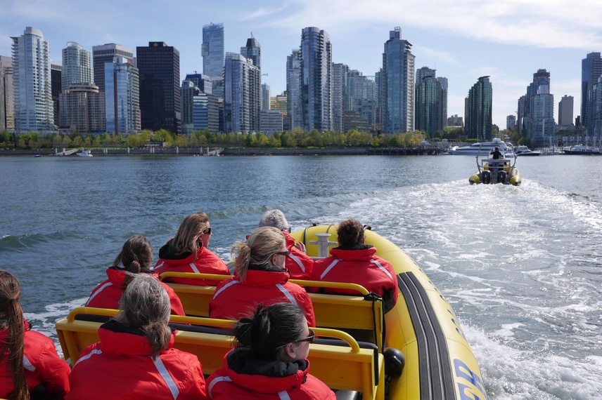 成年人乘船欣赏温哥华天际线。