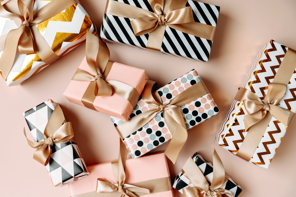 Festive christmas new year background colorful gift boxes and holiday decorations on beige background. New Year's present and Christmas present top view
