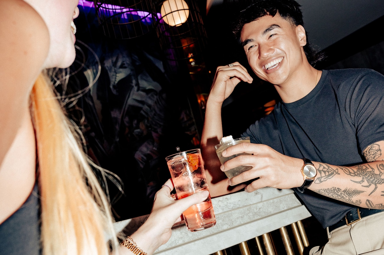 A man sharing a laugh with a girl with cocktails 