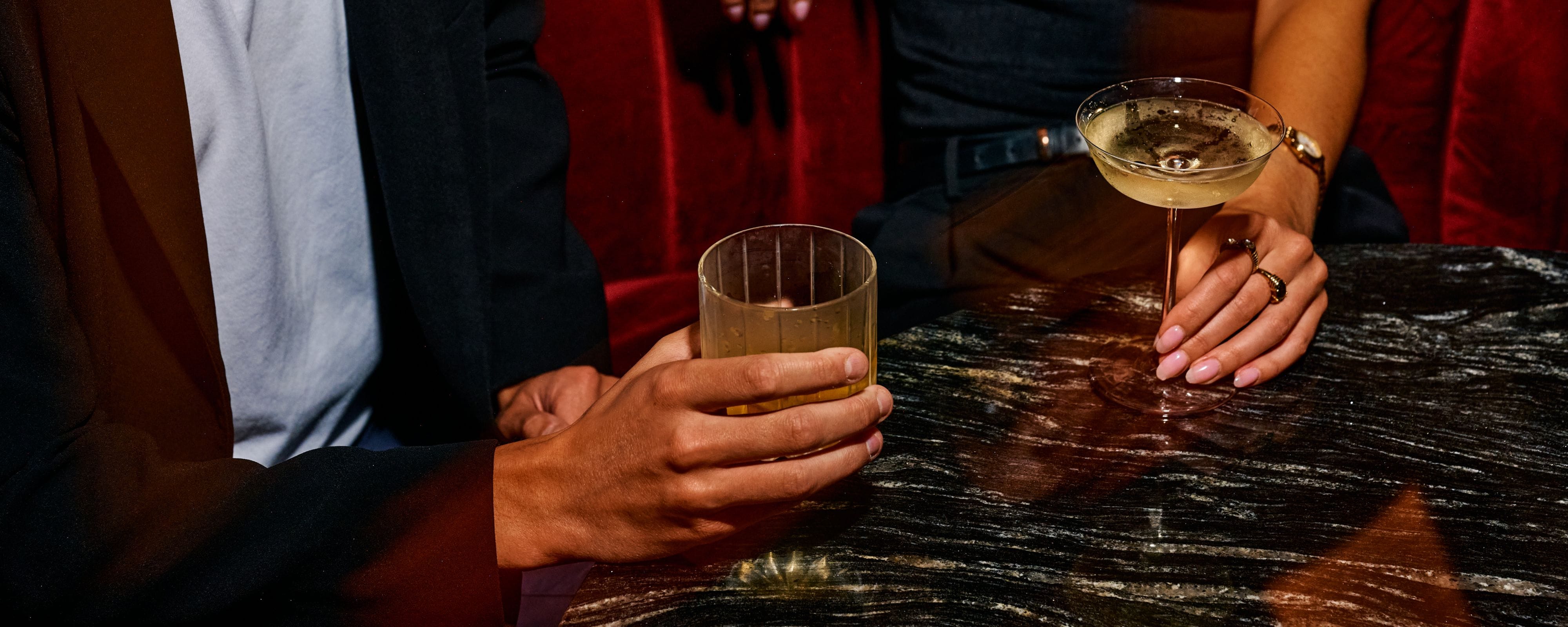 two hands holding wine glasses
