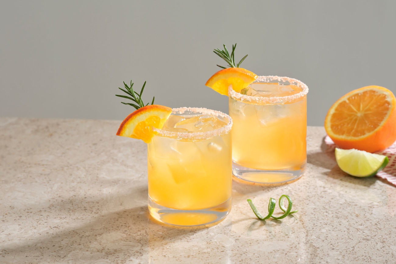 Two cocktails: citrus, floral foam, fruit garnish,