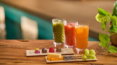 Three drinks by the pool with chocolate and cheese